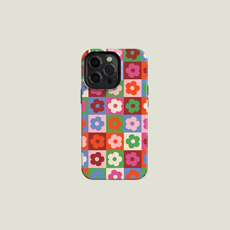 Close-up of the checkered flower iPhone case featuring bold retro grid design in red, green, pink, and blue