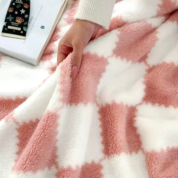 Close-up of a hand touching a pink and white checkered fabric with a book in the background.