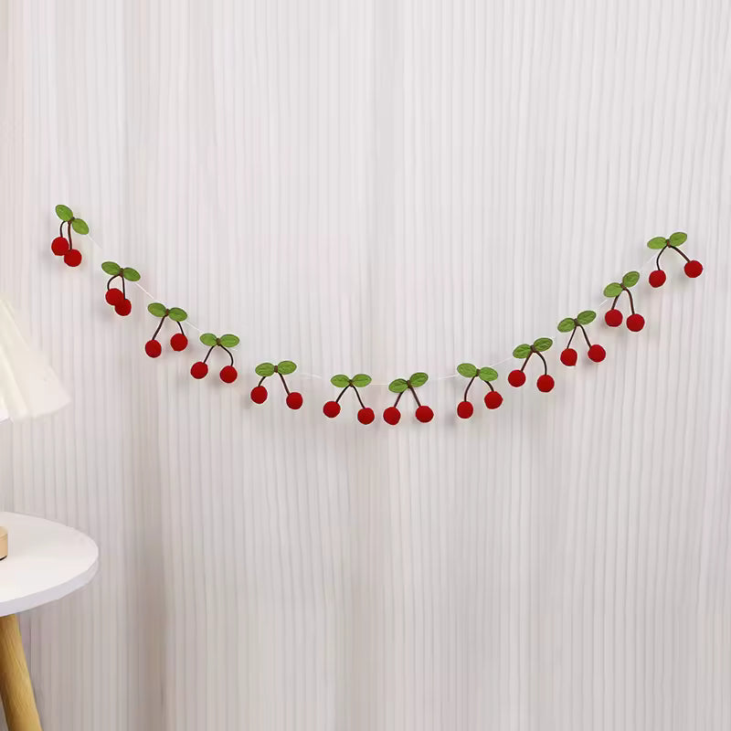 Decorative garland with red berries and green leaves on a white textured wall.