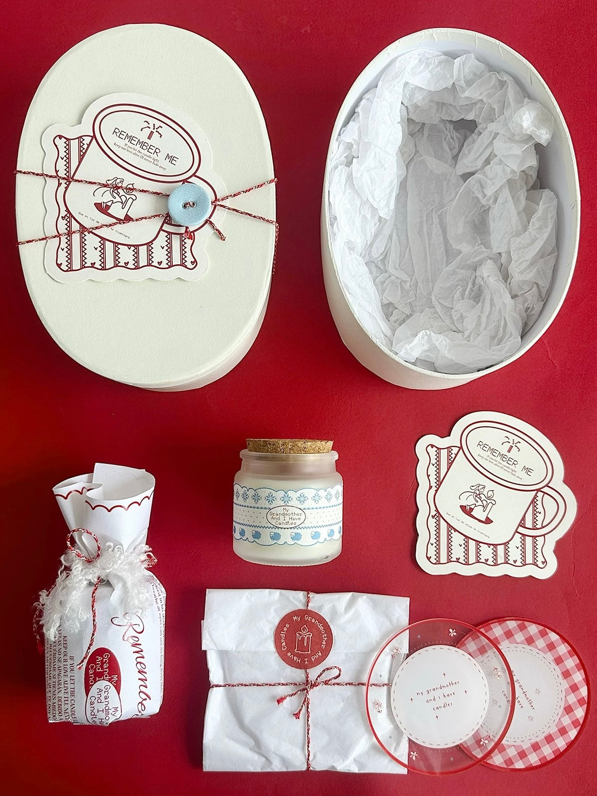 Christmas candle gift box contents arranged on a red background