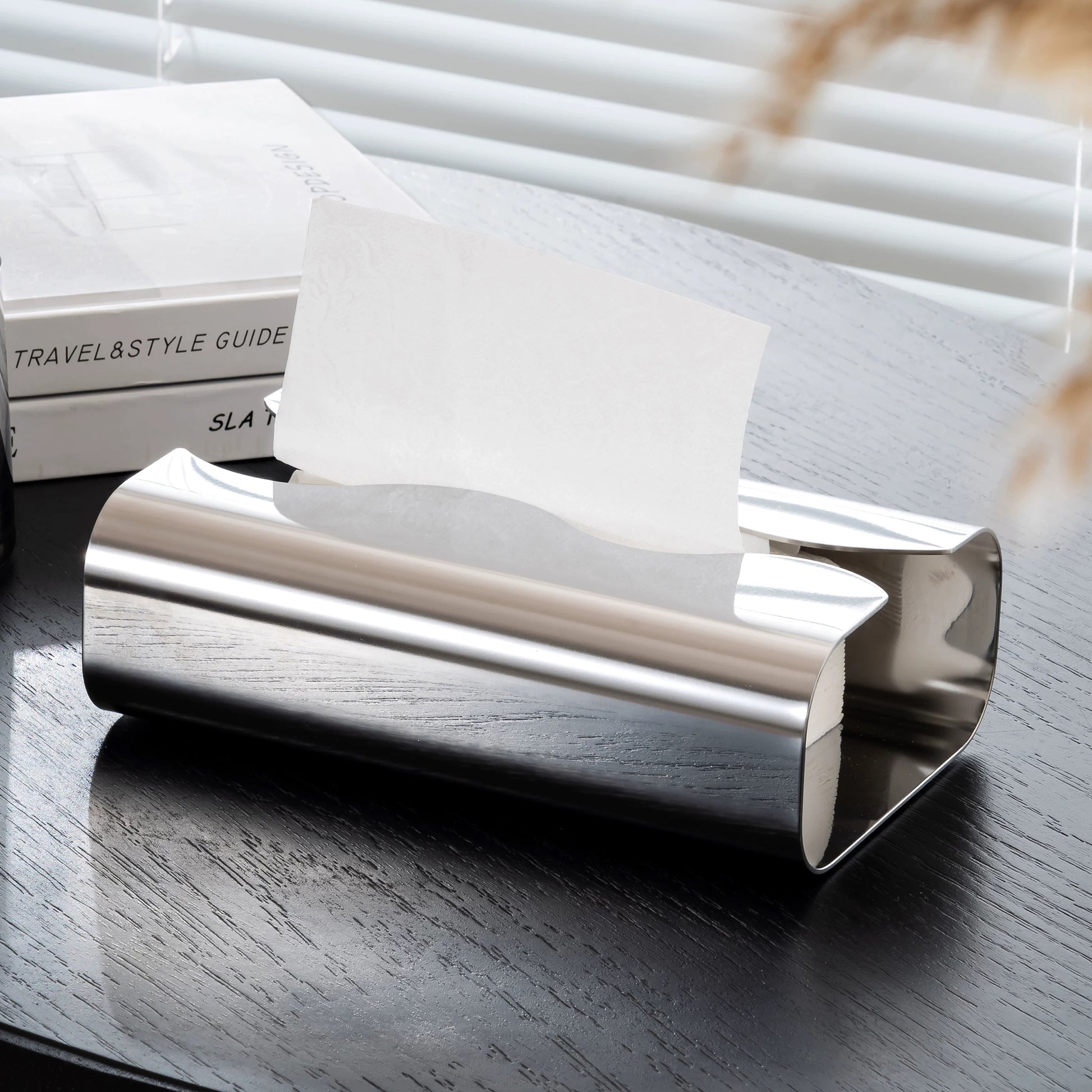 Silver cylindrical object on a reflective surface with a blurred background