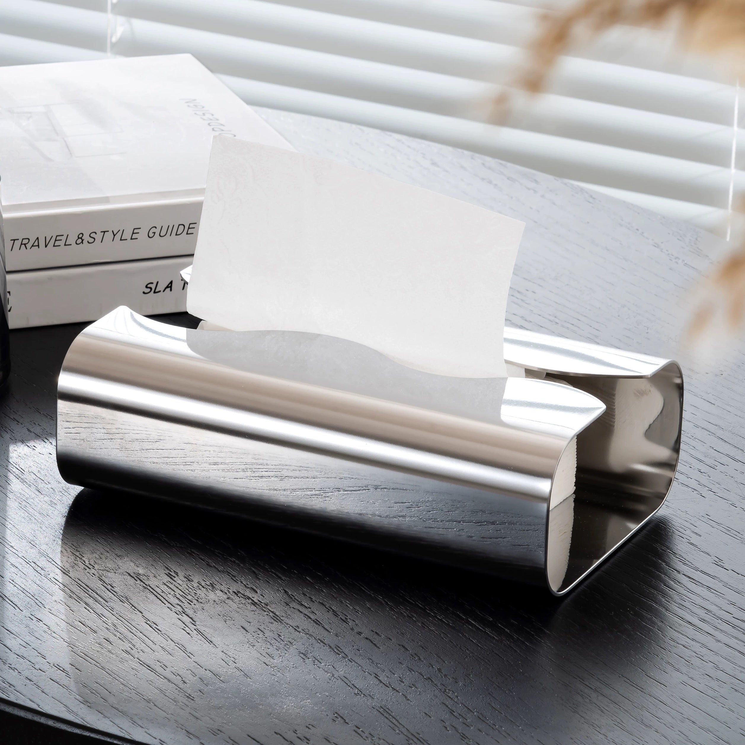 Silver cylindrical object on a reflective surface with a blurred background