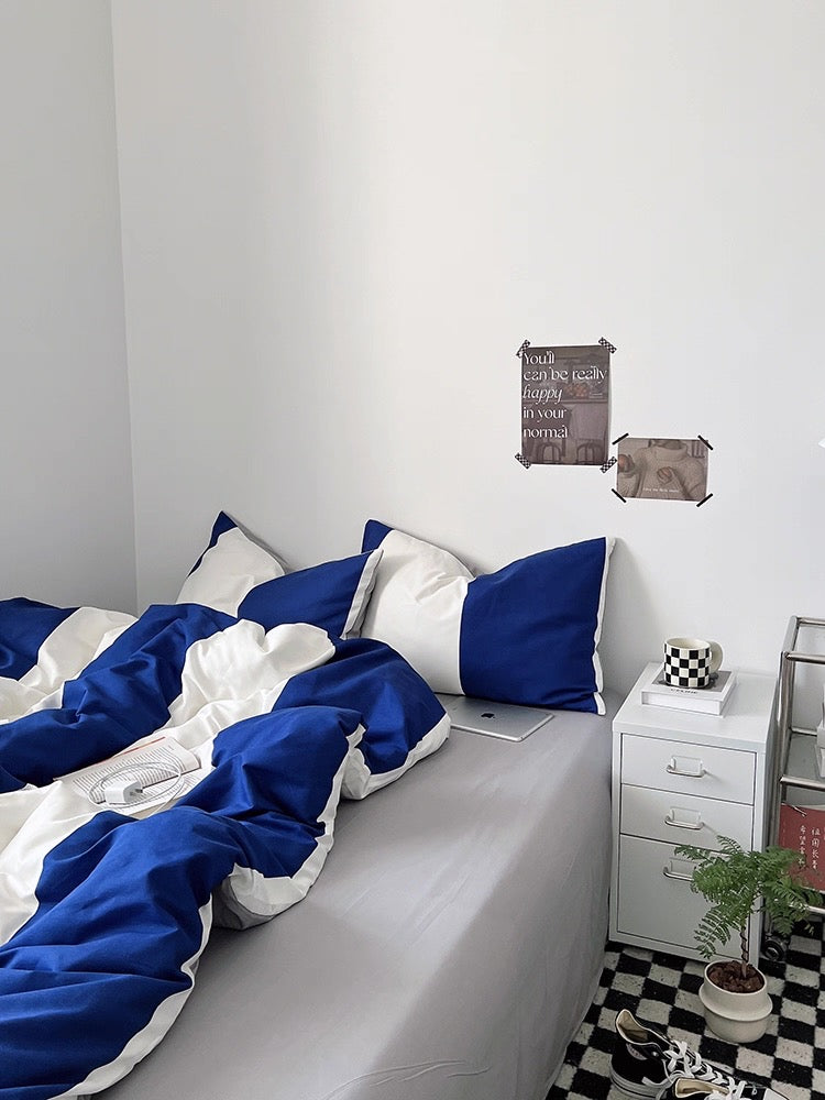 Bedroom with blue and white bedding, nightstands, and decorative items.