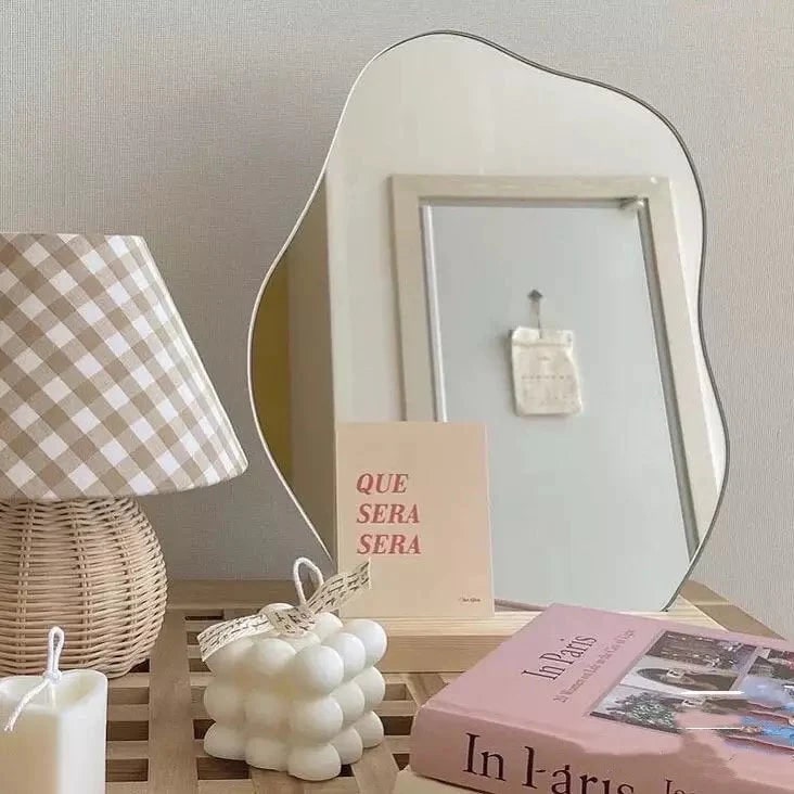 Irregular vanity mirror with wavy acrylic design. Wooden stand adds elegance to soft girl aesthetic room decor or bedroom setups.