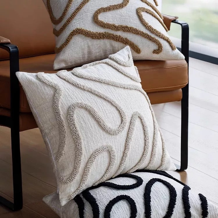 Decorative pillows with textured patterns on a chair.