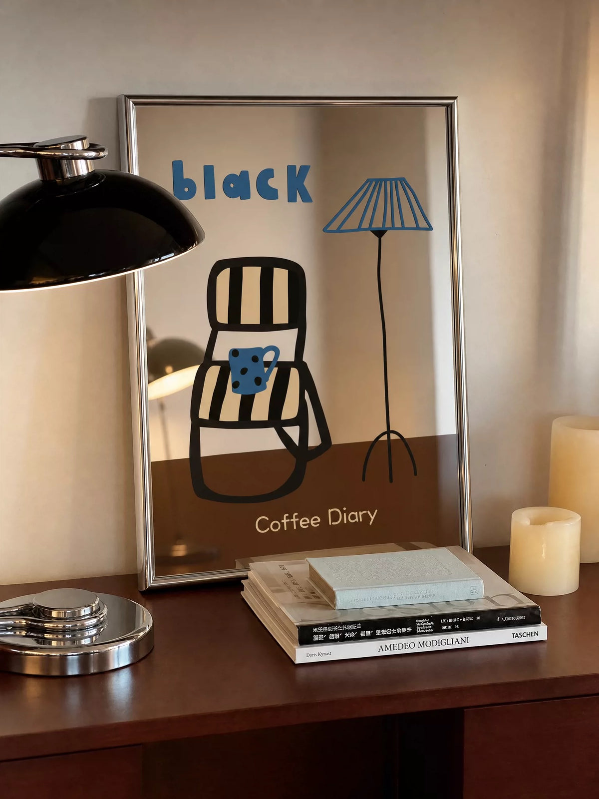 The Coffee Diary mirror shows a black chair, a blue mug and an illustrated floor lamp above a brown panel.