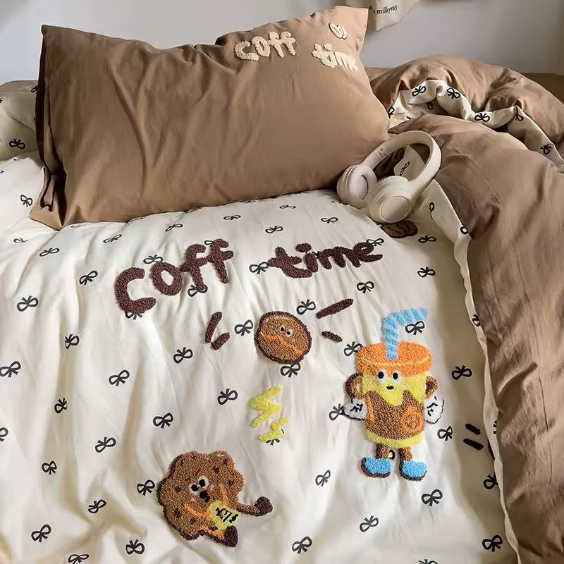 Aesthetically arranged bed featuring coffee‑themed duvet, brown pillowcases and playful embroidery for kawaii room decor