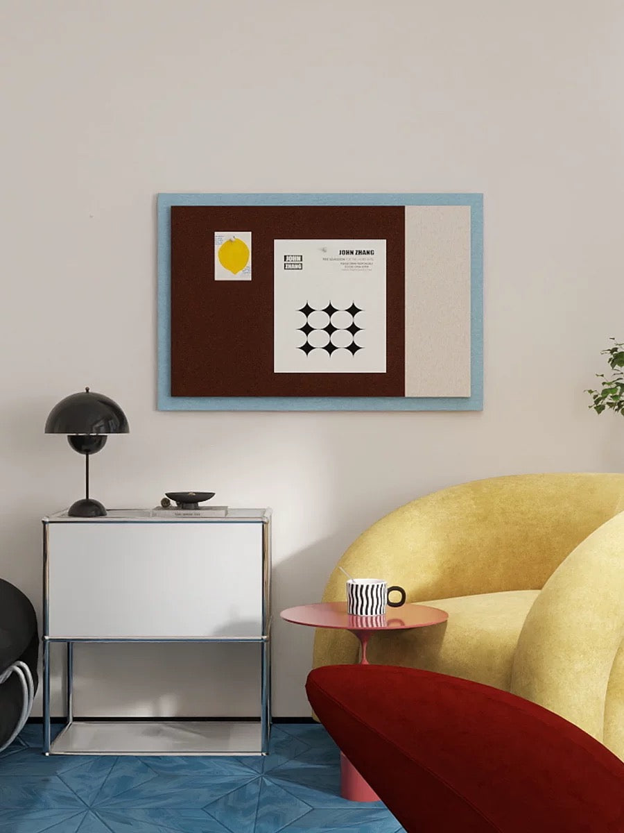 Color block pin board display styled above a desk with a yellow sofa