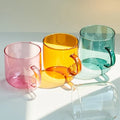 Colorful glass coffee mug with pink handle for aesthetic kitchen decor