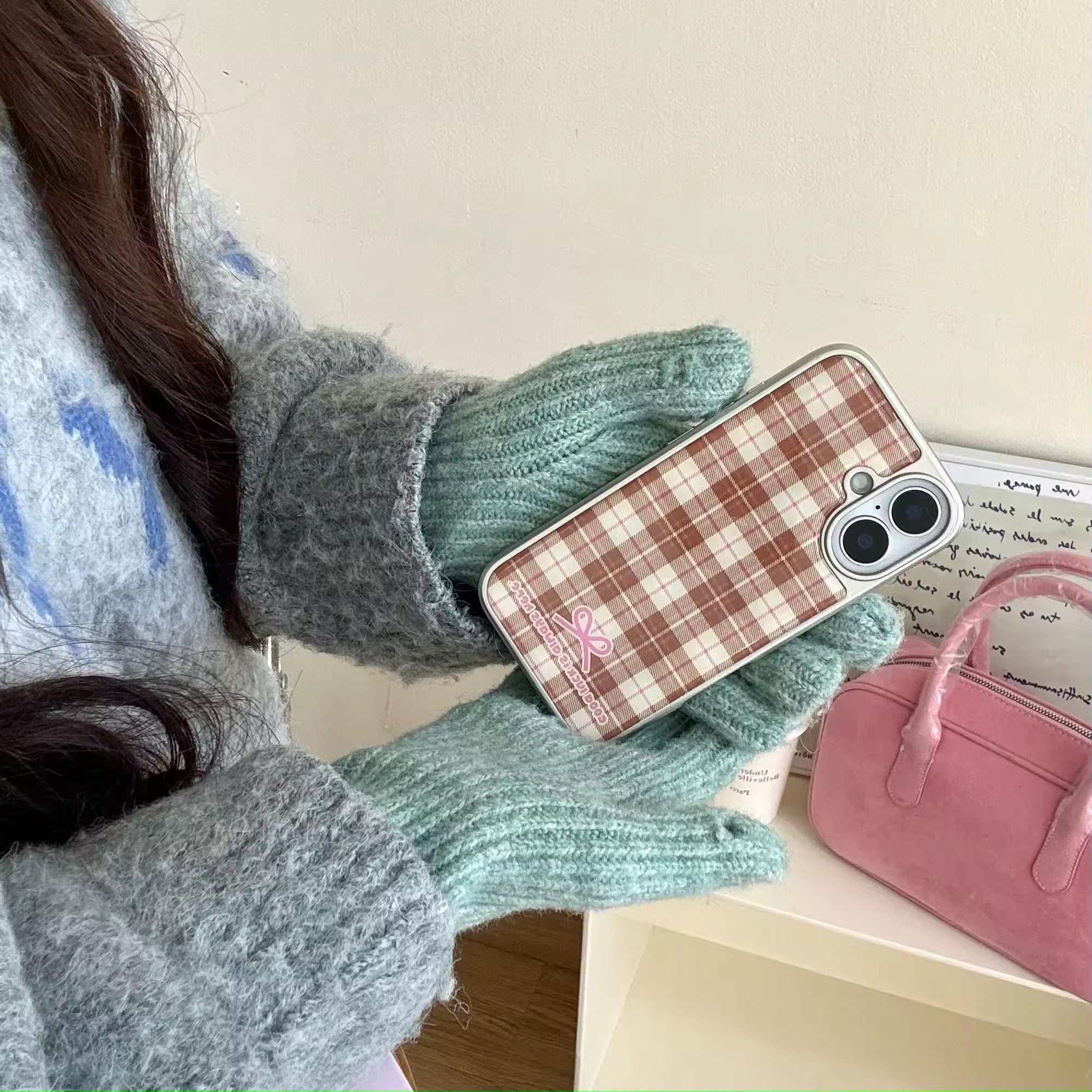 Two vintage-inspired plaid iPhone cases side by side on a pastel surface with soft props