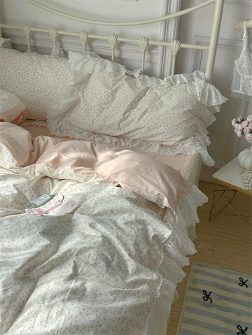 Bed with ruffled bedding and pillows in a softly lit room.