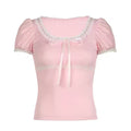 A feminine coquette pink top with a delicate lace bow and puff sleeves.