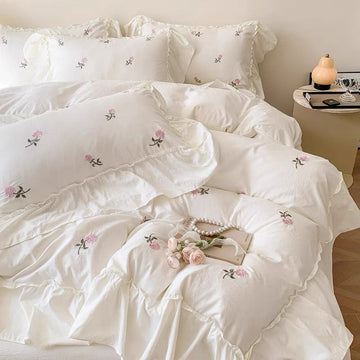 Creamy white rose duvet cover with pink embroidered flowers and ruffle trim