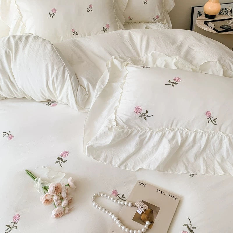 Creamy white floral duvet cover with layered ruffle trim and embroidered roses