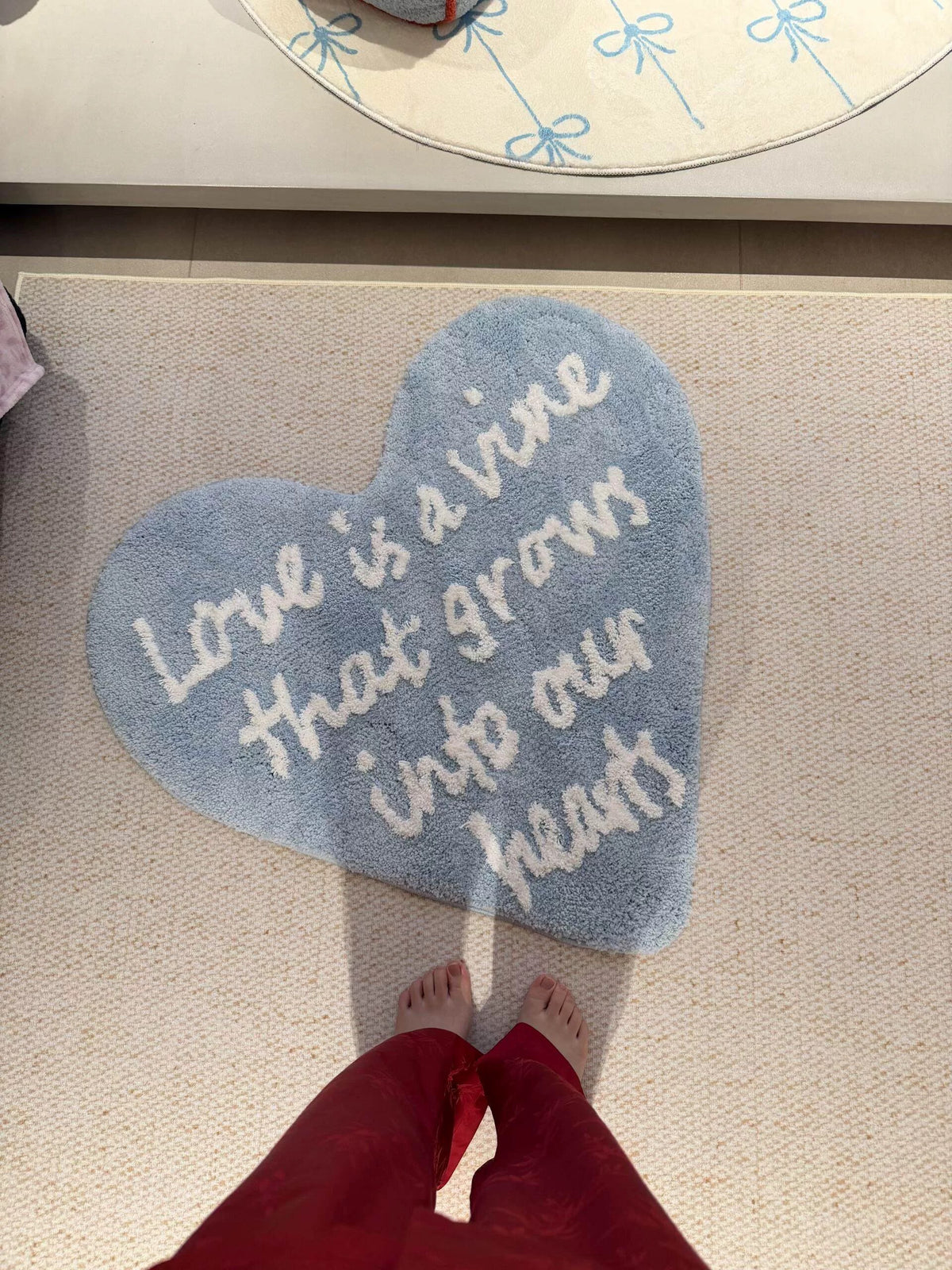 Blue and white Coquette rug seen from above, with curling script arranged inside an uneven heart outline.