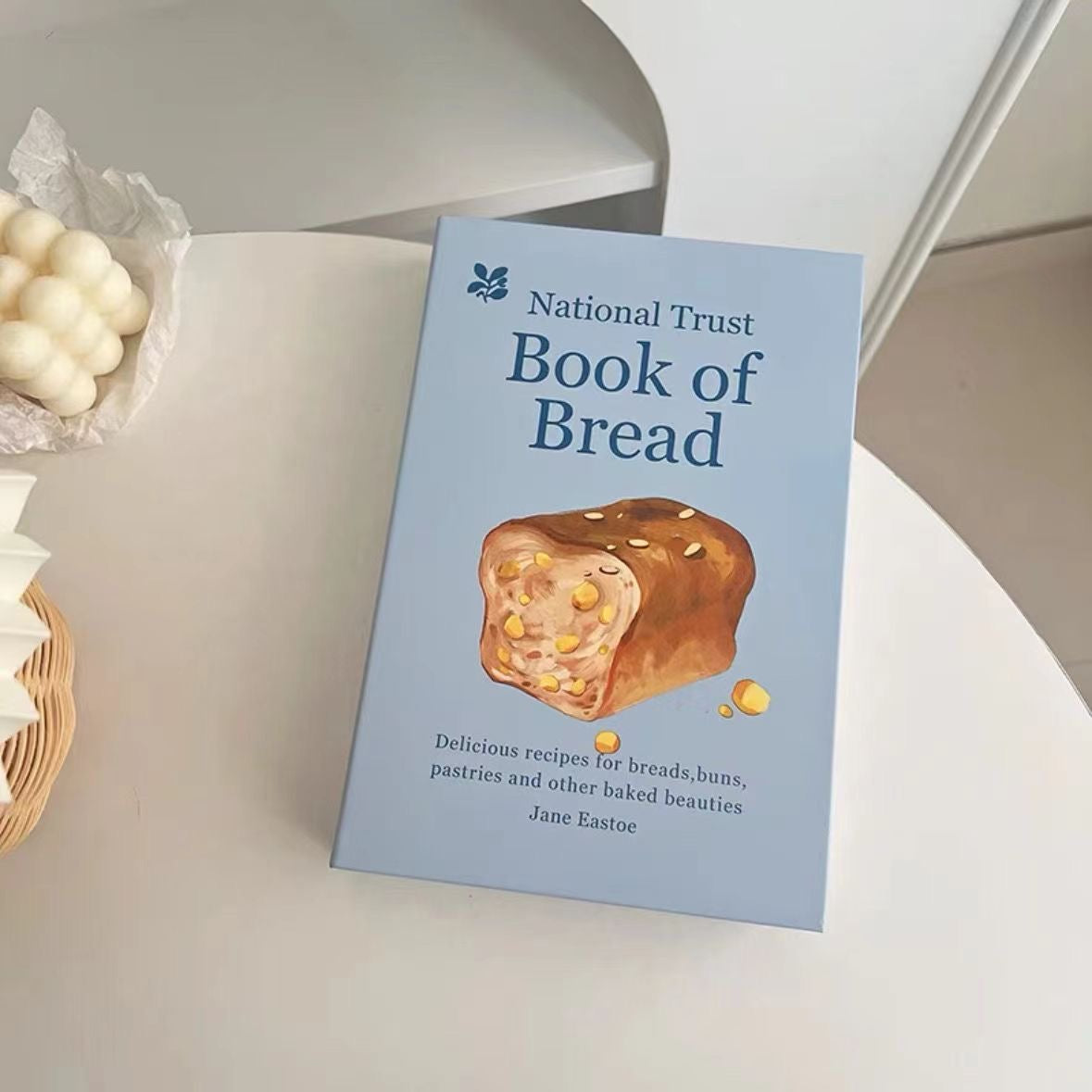 Book titled 'National Trust Book of Bread' on a white surface with a slice of bread illustration.