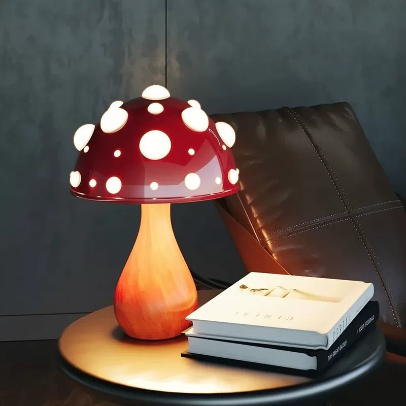 Mushroom-shaped lamp on a table with books against a dark background