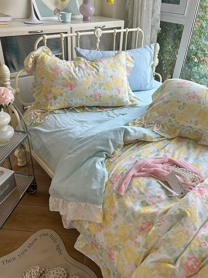Floral cotton pillowcases arranged above a light blue sheet