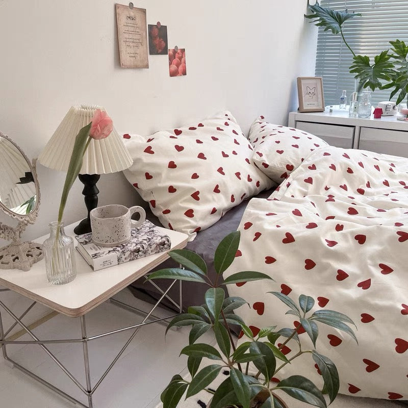 Cotton heart bedding with red heart print arranged across a white bed