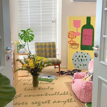 Living room with a colorful abstract painting, armchair, and pink sofa.