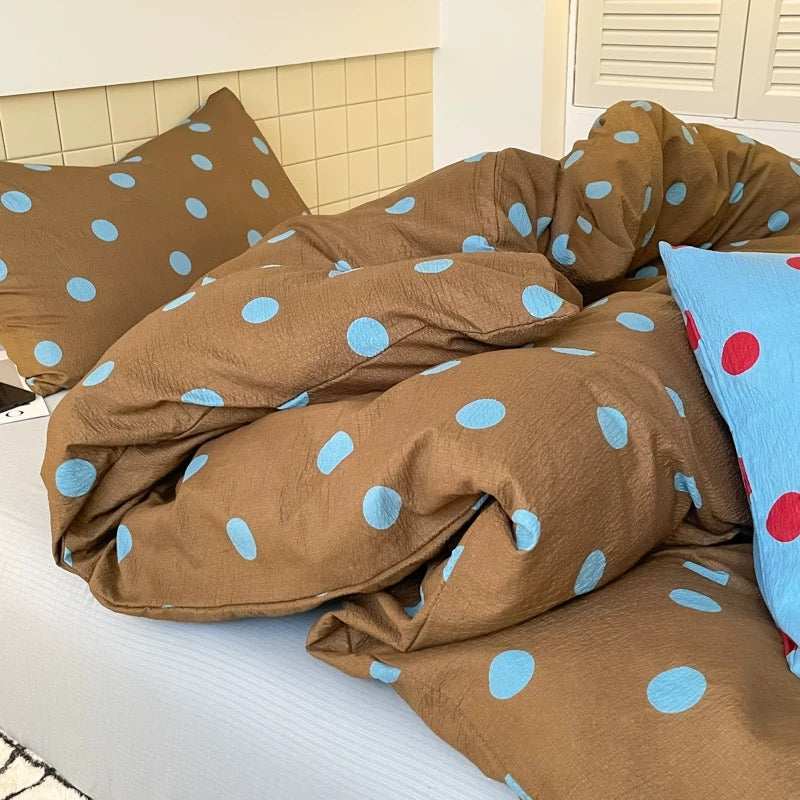 Cozy brown polka dot bedding set creating warm dorm room atmosphere with soft lighting