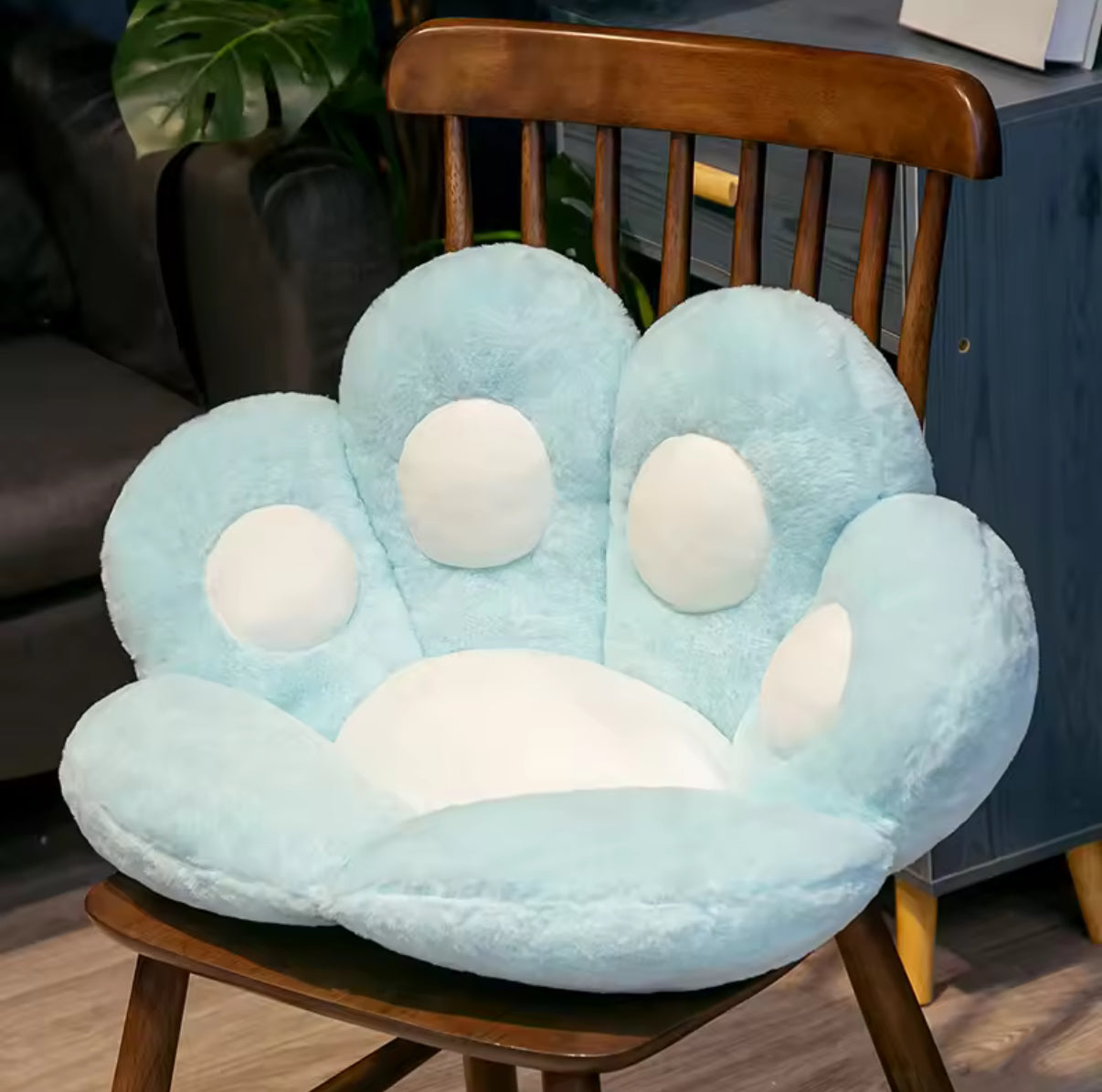 Blue paw-shaped cushion on a wooden chair in a room setting