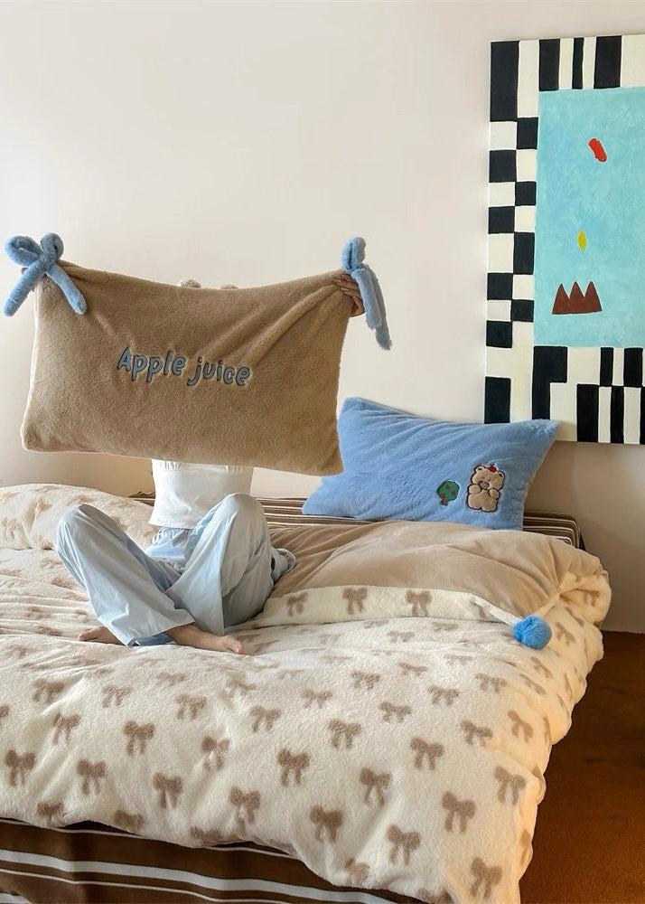 Person lying on a bed with a decorative pillow and a painting on the wall.