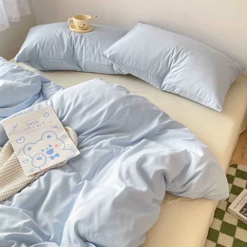 Cream and blue bedding set with soft pastel duvet cover and cream sheet in cozy bedroom.