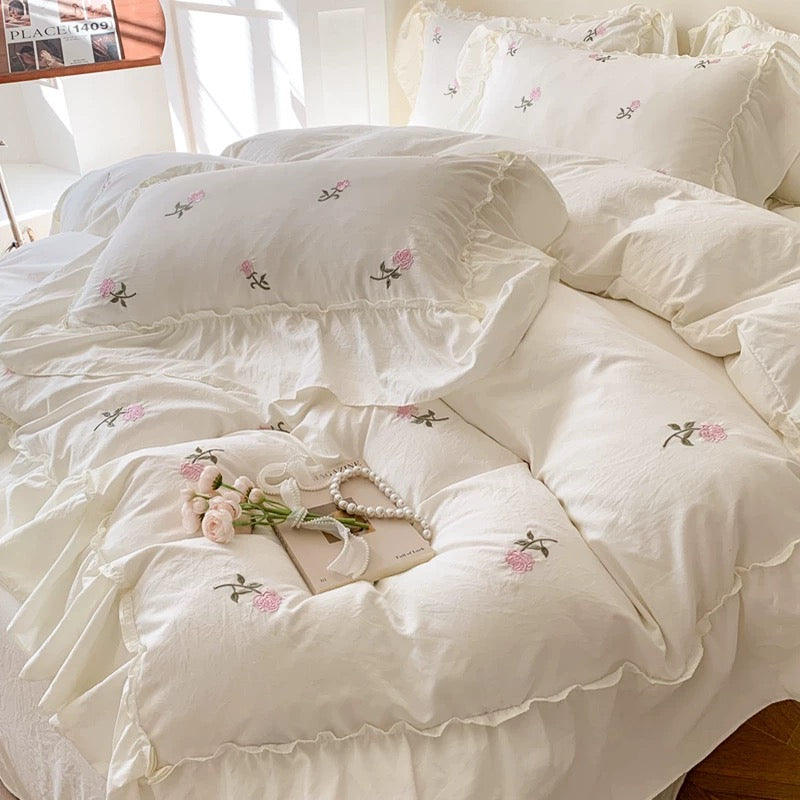 Creamy white rose duvet cover with pink embroidered flowers and ruffle trim