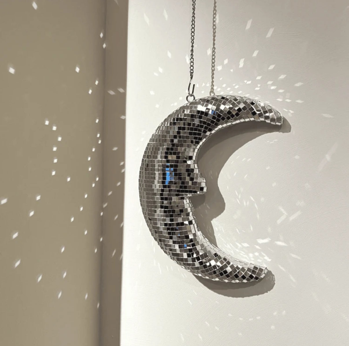 Hanging crescent mirror ball moon in dreamy coquette room

