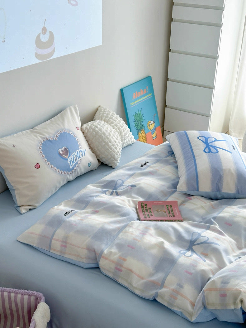 Children's bedroom with light blue bedding and decorative pillows.