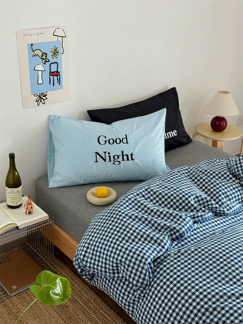 Bedroom with 'Good Night' pillow and checkered duvet