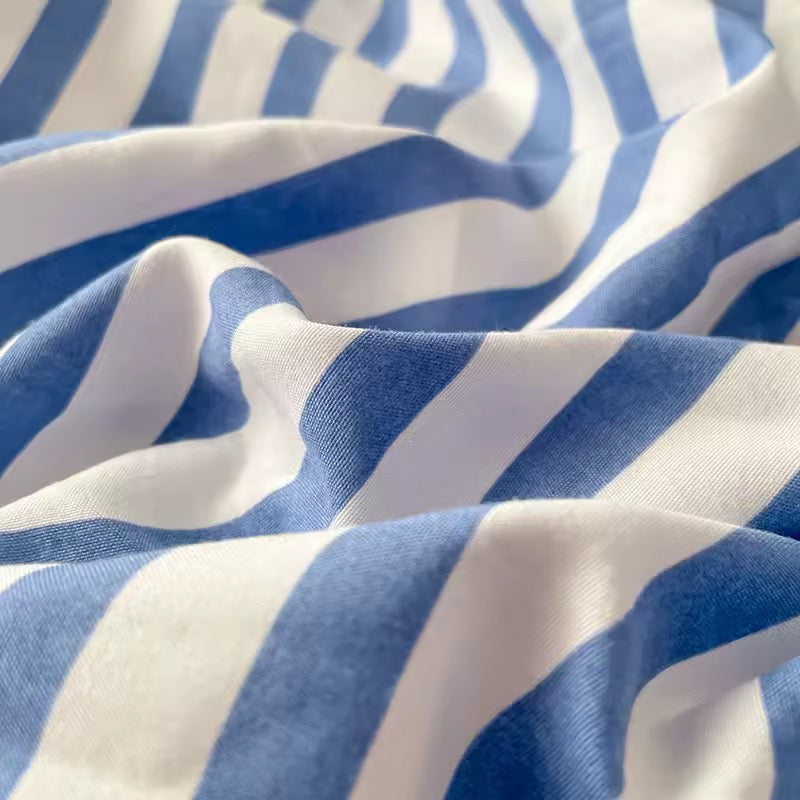 Korean style dorm makeover with blue striped bedding and pastel aesthetic wall decor.