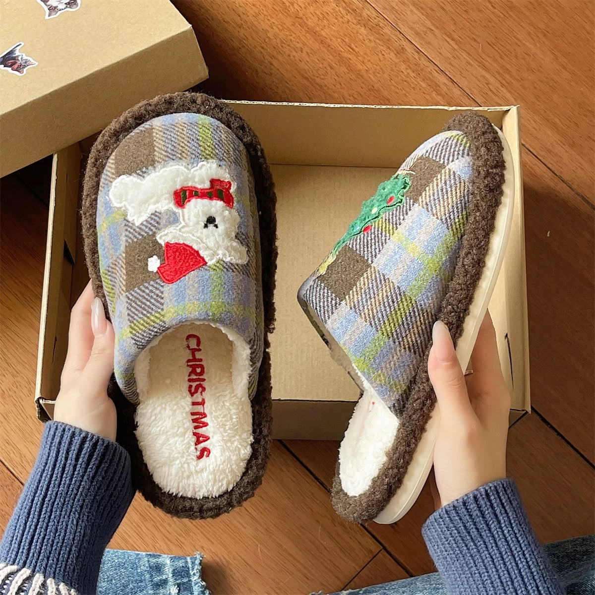 Blue and brown cute Christmas slippers shown beside an open box