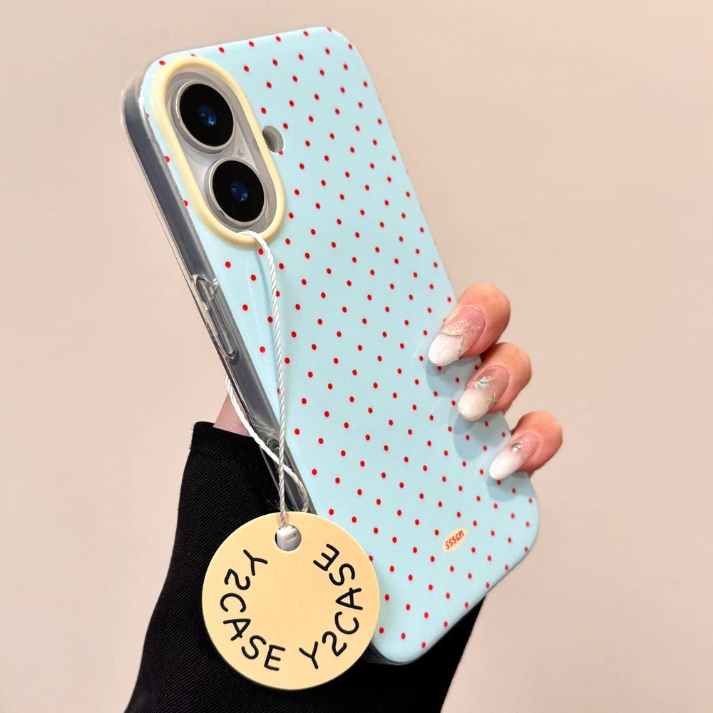 Phone case with polka dot design held by a hand, featuring a visible brand tag.