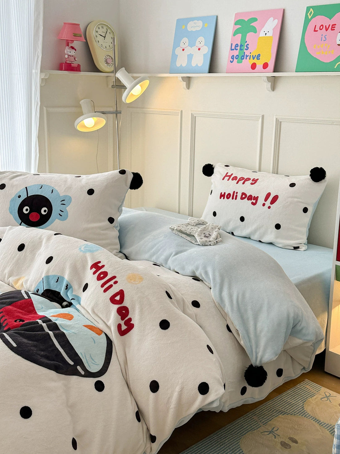 Penguin milk fleece bedding set styled on bed with pom pom pillows in cozy winter room