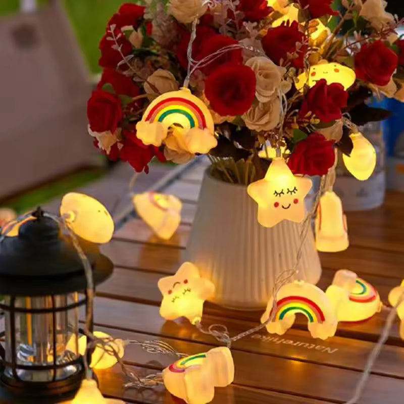 String lights with cartoon designs on a wooden surface with flowers in the background