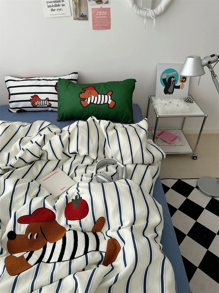 Striped bedding with cartoon dog design on a bed in a room with a checkered floor.