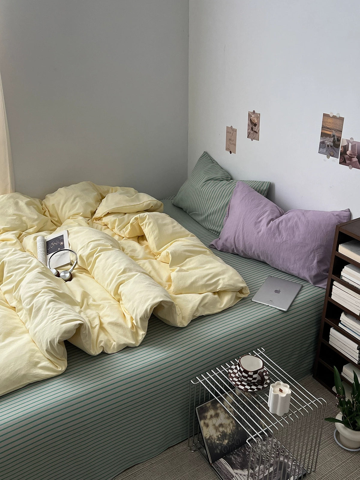 Danish pastel bedding with butter yellow duvet and sage striped sheet on a low bed