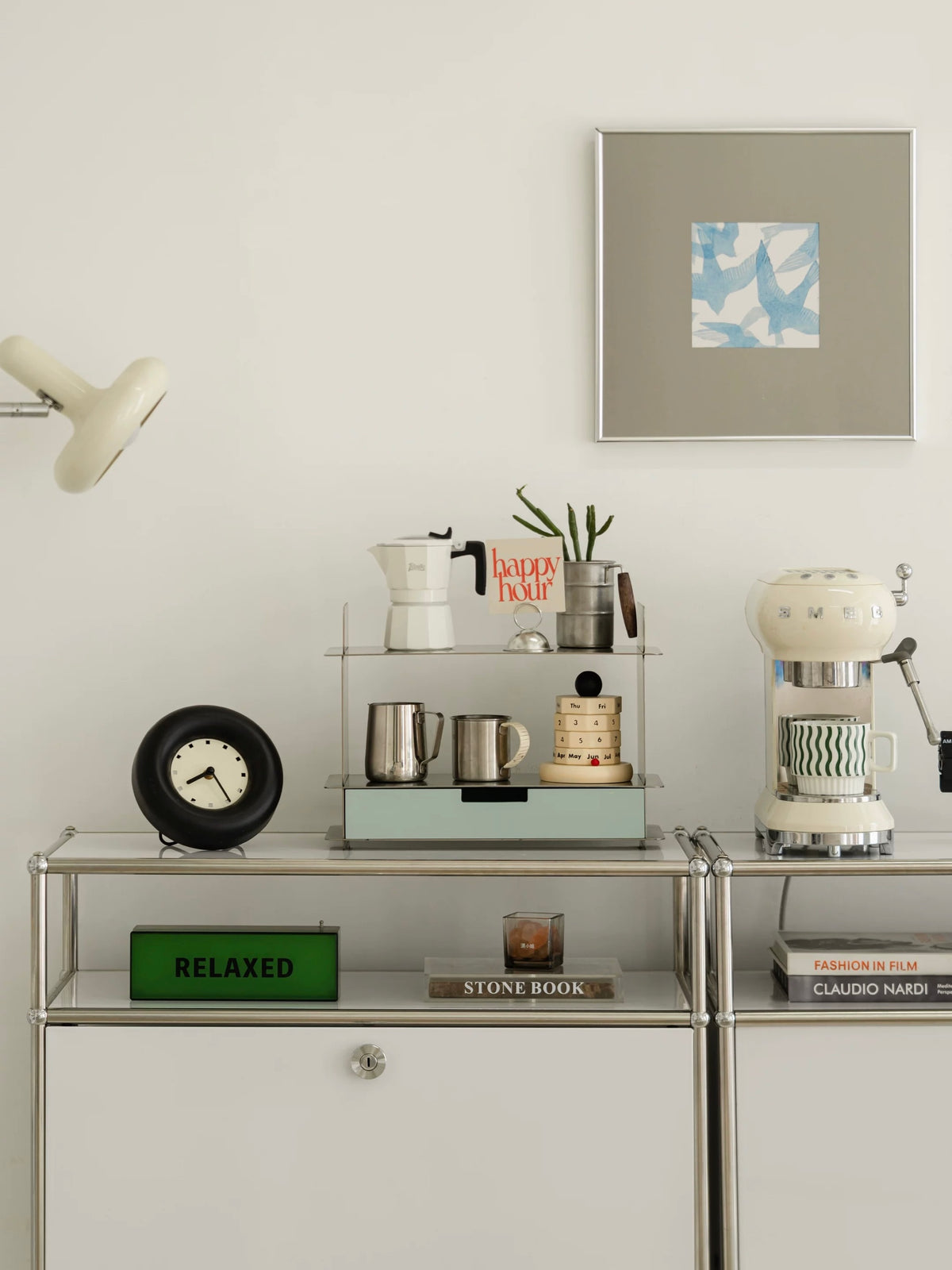Desk shelf with a drawer on a white cabinet beside a green sign and a framed print