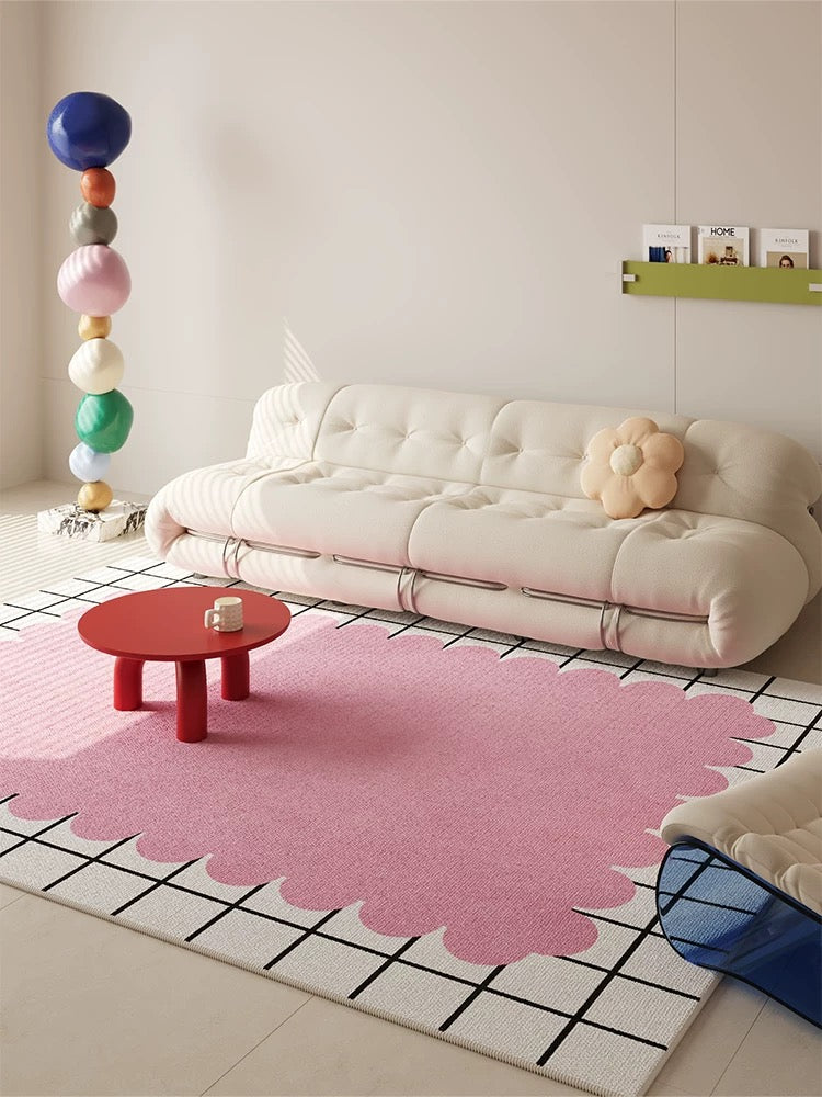 Modern living room with a pink rug, white sofa, and colorful decor elements.