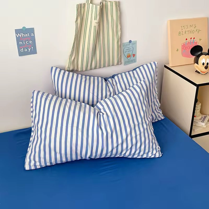 Cozy preppy room featuring blue striped duvet cover set with flat sheet and pillowcases.