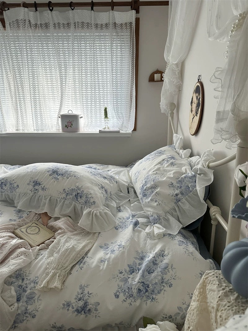 French country bedroom with blue floral lace ruffle bedding and vintage decor.