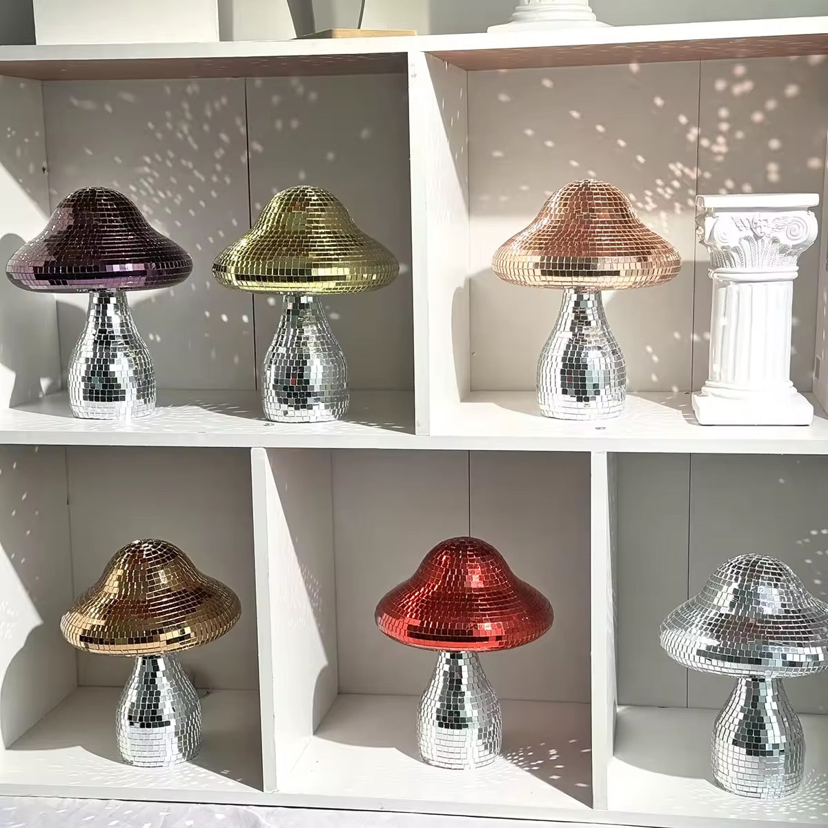 Handmade disco mushroom ornament on pastel shelf glowing with light