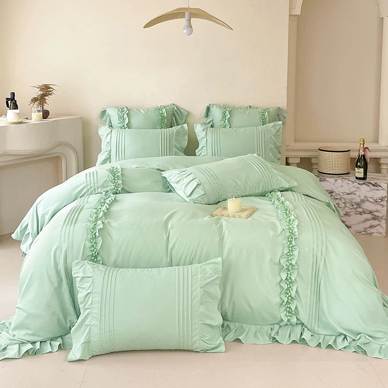 Mint green bedding set on a bed in a bedroom setting.