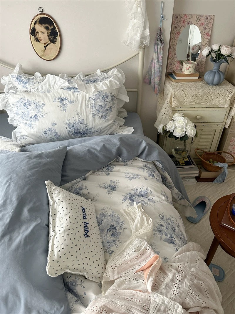 Romantic blue floral cotton duvet set styled with pastel throw pillows.