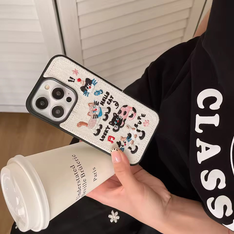 Phone case with cartoon design held by a person wearing a black shirt with 'CLASS' text.