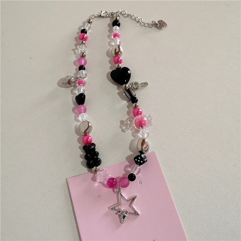 Handmade pink beaded choker with gothic and vintage Y2K aesthetic charms including cross, bow, and wings pendants for women.