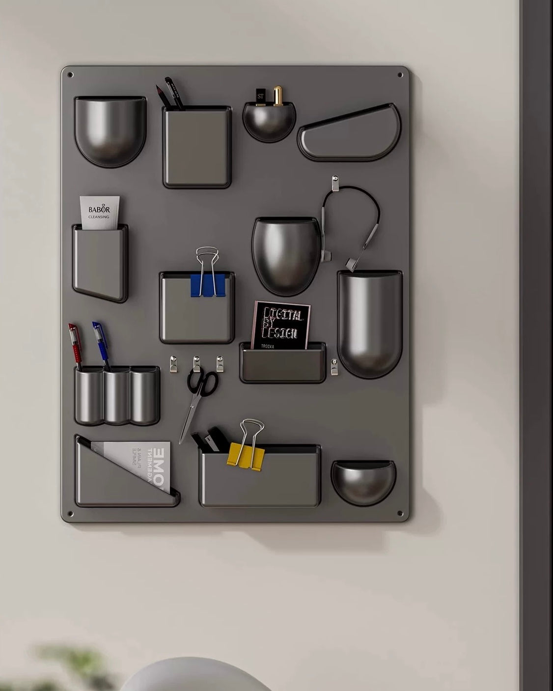 Gray wall-mounted organizer with various office supplies on a light gray background