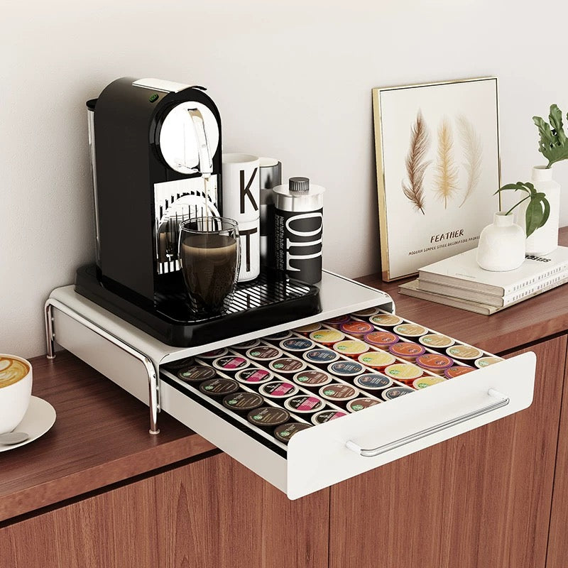 Coffee machine with a drawer full of coffee pods on a wooden surface.